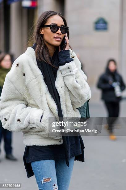 French model Cindy Bruna wearing a white fur jacket, black scarf, green bagpack outside Elie Saab on January 25, 2017 in Paris, Canada.