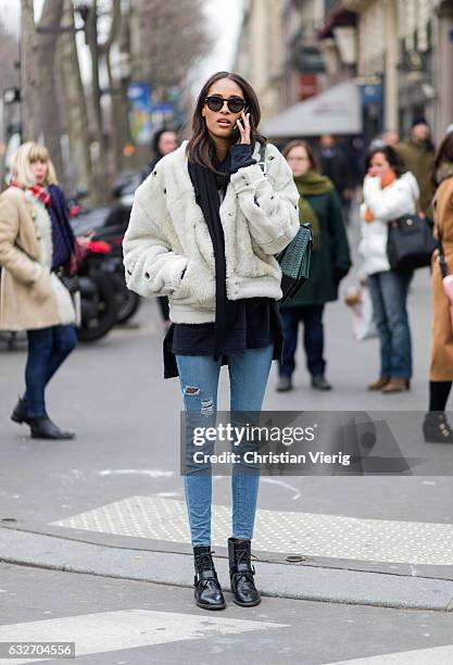 French model Cindy Bruna wearing a white fur jacket, black scarf, green bagpack outside Elie Saab on January 25, 2017 in Paris, Canada.