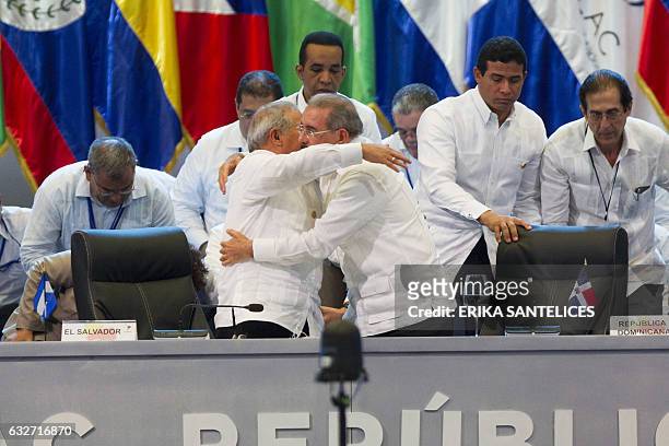 Salvadoran President Salvador Sanchez Ceren receives the pro tempore presidency from his Dominican Republic counterpart Danilo Medina during the...