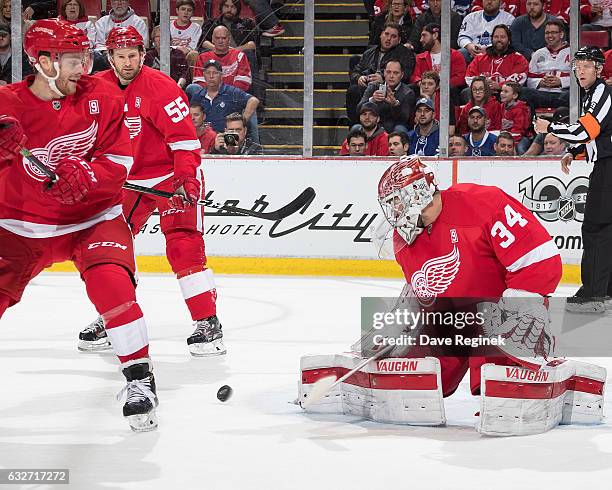 Petr Mrazek of the Detroit Red Wings makes a pad save while teammates Niklas Kronwall and Nick Jensen look for the rebound during an NHL game against...