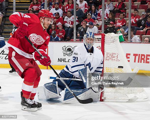 Goaltender Frederik Andersen of the Toronto Maple Leafs bats the puck away as Gustav Nyquist of the Detroit Red Wings look for the rebound during an...