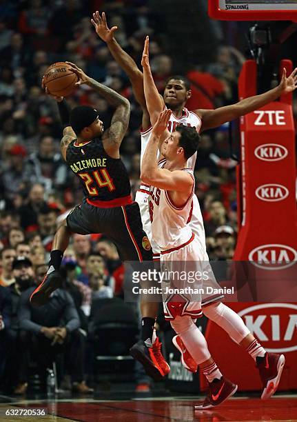 Kent Bazemore of the Atlanta Hawks tries to get off a shot against Paul Zipster and Cristiano Felicio of the Chicago Bulls at the United Center on...