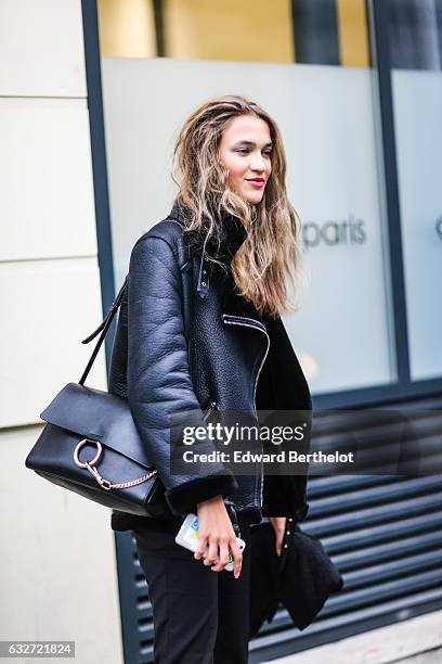 Model wears a black aviator coat with fur, and a Chloe Faye bag, outside the Jean Paul Gaultier show, during Paris Fashion Week Haute Couture Spring...