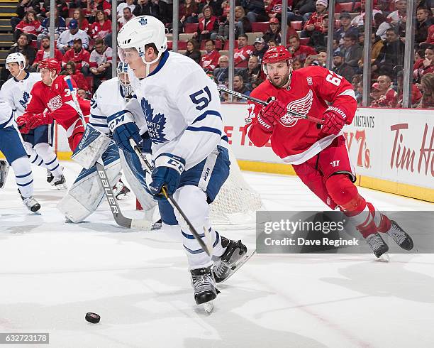 Jake Gardiner of the Toronto Maple Leafs skates with the puck around the net followed by Thomas Vanek of the Detroit Red Wings during an NHL game at...
