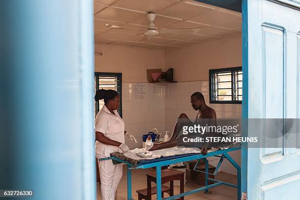 Nurse tends to a man at the Raoul Follereau Foundation for leprosy screening in Pobe on January 12, 2017. In the west african country of Benin,...