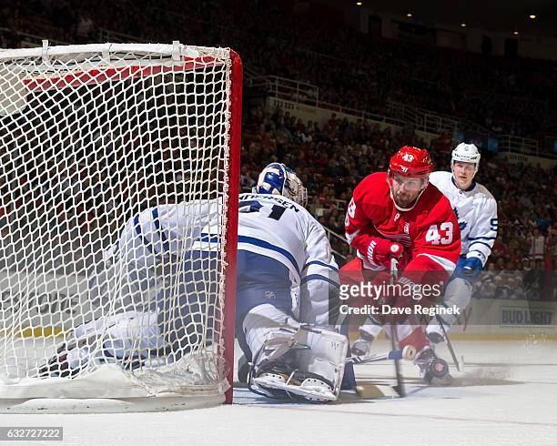 Darren Helm of the Detroit Red Wings skates in with the puck looking to score on Frederik Andersen of the Toronto Maple Leafs as Jake Gardiner of the...