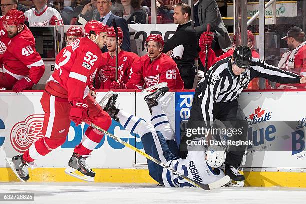 Jonathan Ericsson of the Detroit Red Wings skates behind Nikita Soshnikov of the Toronto Maple Leafs as he crashes into linesman Scott Driscoll...