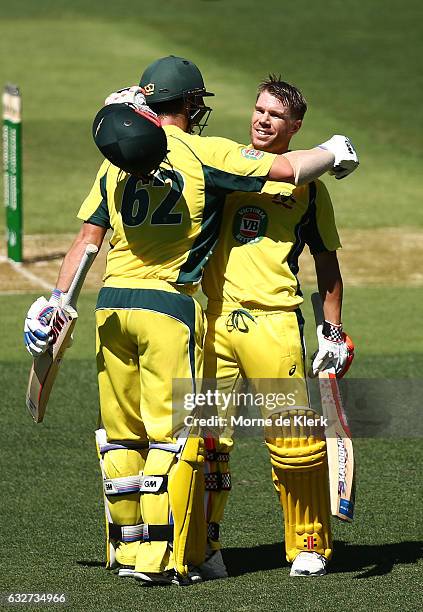 Travis Head of Australia congratulates teammate David Warner after he reached 100 runs during game five of the One Day International series between...