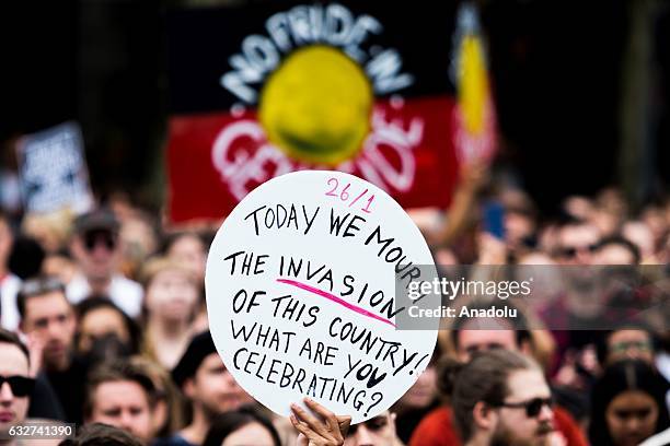 Protester holds a banner during a protest, organized by Aboriginal rights activists on Australia Day in Melbourne, Australia on January 26, 2017....