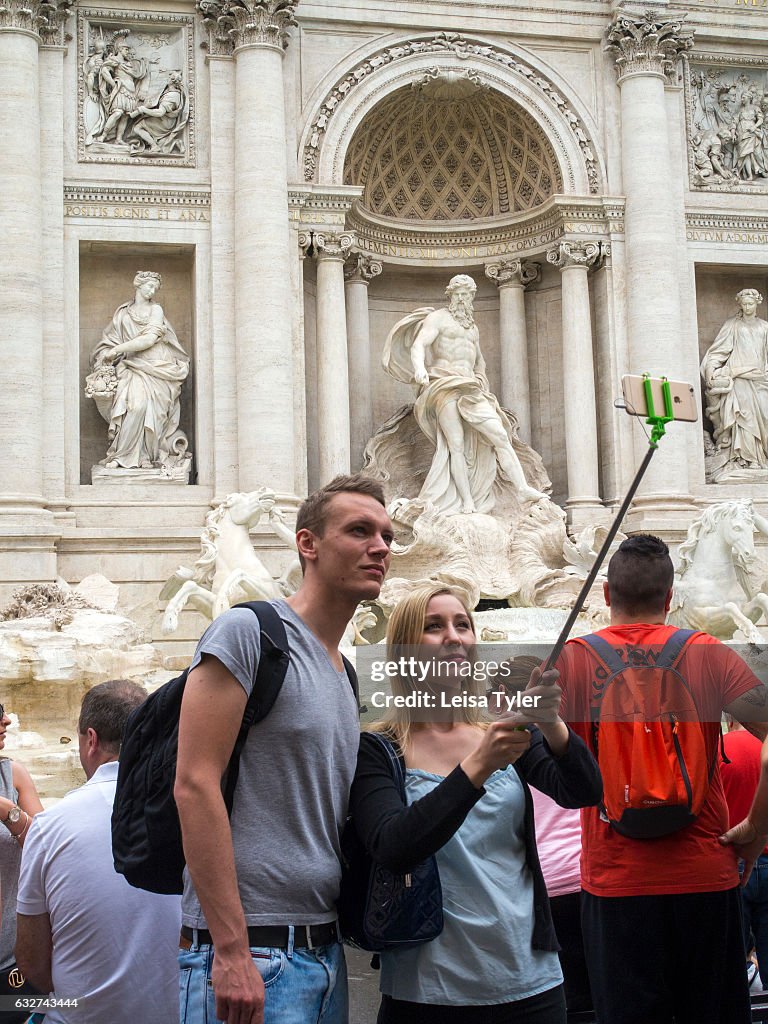 Tourists taking selfies at the Trevi Fountain in Rome, Italy...