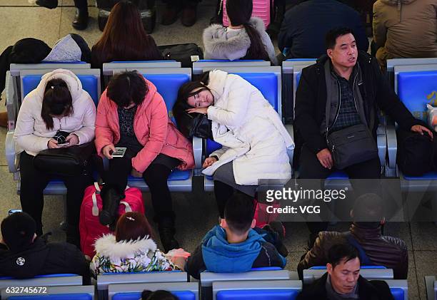 Passengers wait for their trains at a waiting hall of Shenyang North Railway Station on January 26, 2017 in Shenyang, Liaoning Province of China. The...