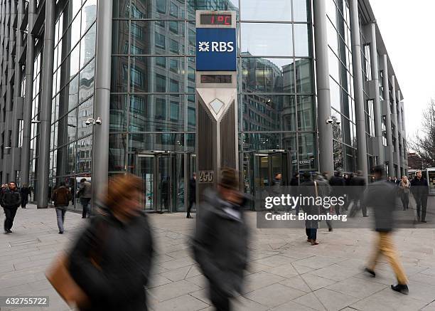 Pedestrians pass a sign at a Royal Bank of Scotland Group Plc headquarters in London, U.K., on Thursday, Jan. 26, 2017. RBS said it will take a 3.1...