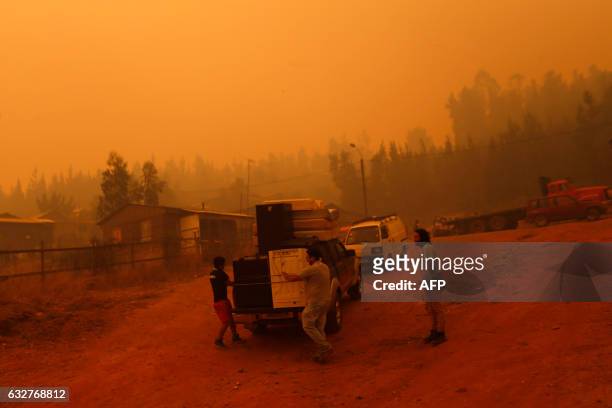 People evacuate San Ramon after a forest fire devastated the nearby town of Santa Olga, 240 kilometres south of Santiago, on January 26, 2017. Six...