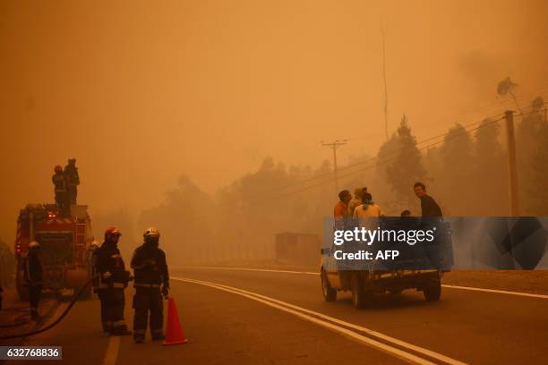 People evacuate San Ramon after a forest fire devastated the nearby town of Santa Olga, 240 kilometres south of Santiago, on January 26, 2017. Six...