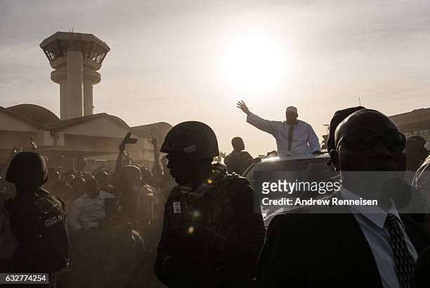 Gambian President Adama Barrow is surrounded by military police as he arrives at Banjul International Airport on January 26, 2017 in Banjul, The...