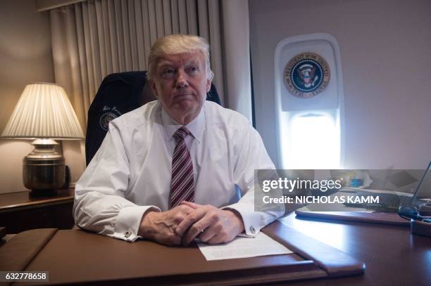President Donald Trump poses in his office aboard Air Force One at Andrews Air Force Base in Maryland after he returned from Philadelphia on January...