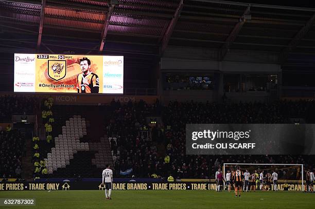 The crowd applaud Hull City's injured English midfielder Ryan Mason after he fractured his skull last week during the EFL Cup semi-final second-leg...