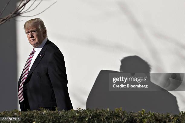 President Donald Trump walks towards the Oval Office through the West Wing Colonnade of the White House after arriving on Marine One in Washington,...