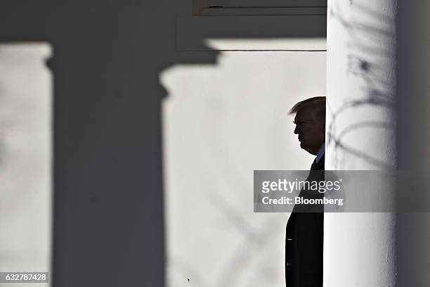 President Donald Trump walks towards the Oval Office through the West Wing Colonnade of the White House after arriving on Marine One in Washington,...