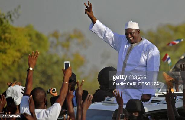 Gambia's new president Adama Barrow waves to supporters as he leaves the airport in Banjul on January 26 after returning from Senegal. Jubilant...
