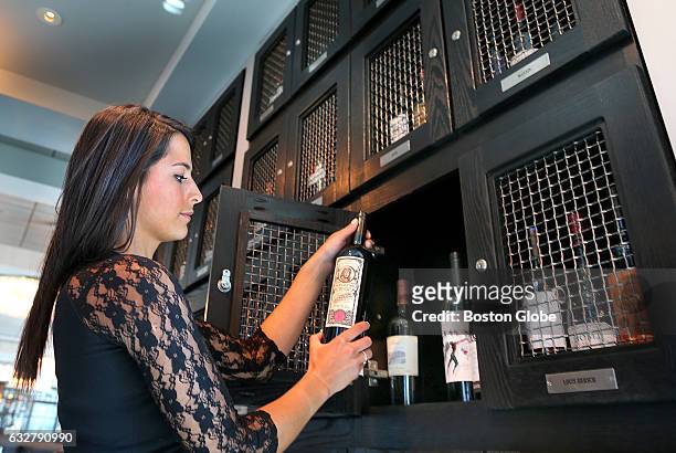 Cocktail server Lindsay Manfra removes a $695 bottle of Melbury Bond red wine from Lionel Richie's personal wine locker at Strega Prime restaurant in...