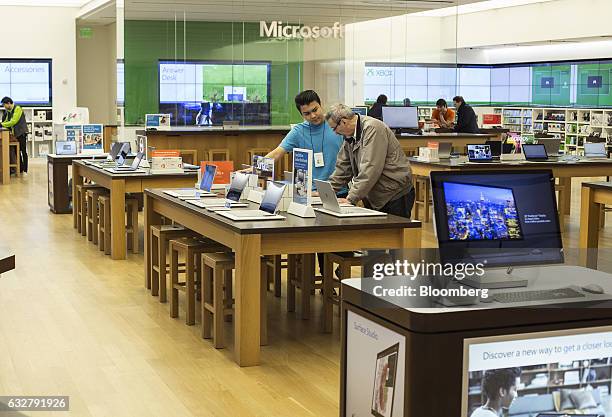 An employee assists a customer at a Microsoft Corp. Store in Bellevue, Washington, U.S., on Thursday, Jan. 26, 2017. Microsoft Corp.'s second-quarter...