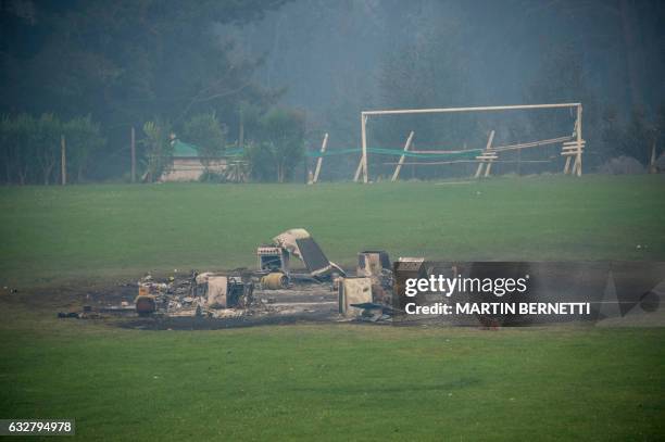 Debris seen in the town of Santa Olga, which was destroyed by a forest fire, 330 km south of Santiago, on January 26, 2017. - Six people -- among...