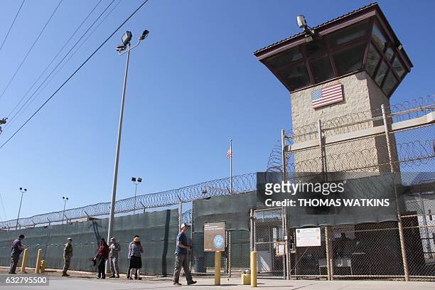 Poeple walk past a guard tower outside the fencing of Camp 5 at the US Military's Prison in Guantanamo Bay, Cuba on January 26, 2017. President...