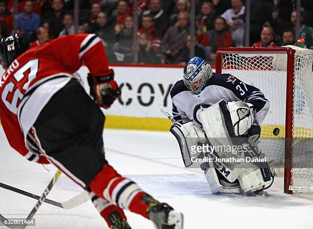 Tanner Kero of the Chicago Blackhawks scores a goal against Connor Hellebuyck of the Winnipeg Jets at the United Center on January 26, 2017 in...