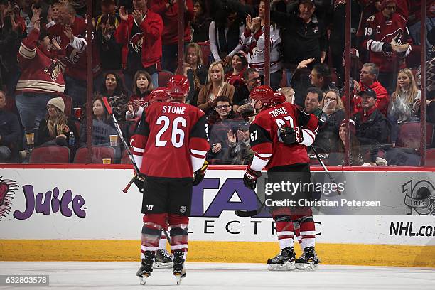 Lawson Crouse of the Arizona Coyotes celebrates with Jordan Martinook and Michael Stone after scoring against the Vancouver Canucks during the second...