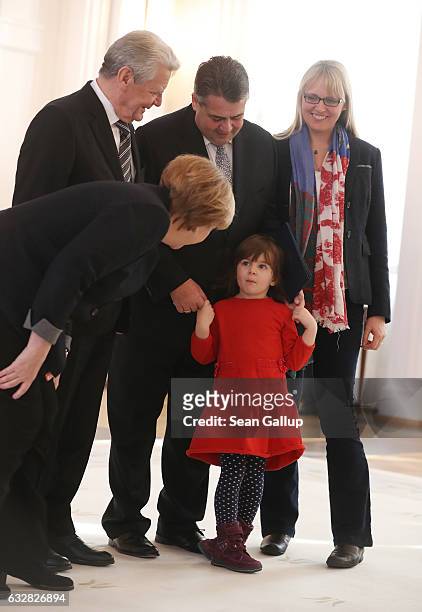 German Chancellor Angela Merkel speaks to Marie daughter of new German Foreign Minister Sigmar Gabriel as President Joachim Gauck and Gabriel's wife...