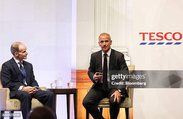 Dave Lewis, chief executive officer of Tesco Plc, right, speaks as Charles Wilson, chief executive officer of Booker Group Plc, looks on during a...