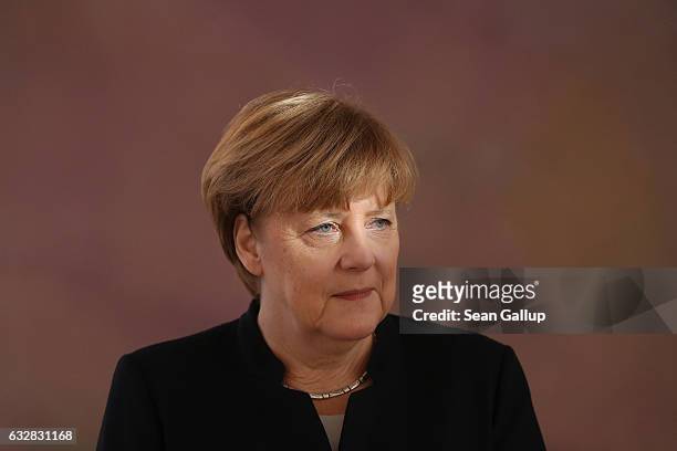 German Chancellor Angela Merkel, whose eyes are illuminated by sunlight, attends a ceremony in which President Joachim Gauck appointed Sigmar Gabriel...