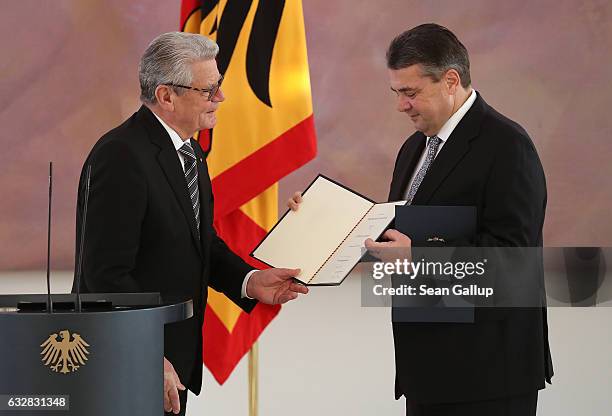 German President Joachim Gauck gives Sigmar Gabriel his official papers to appoint him as Germany's new foreign minister during a ceremony at Schloss...