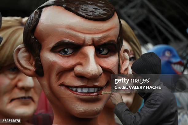 Man puts the final touche to a giant figure depicting presidential candidate Emmanuel Macron, on January 27, 2017 in Nice, southeastern France,...