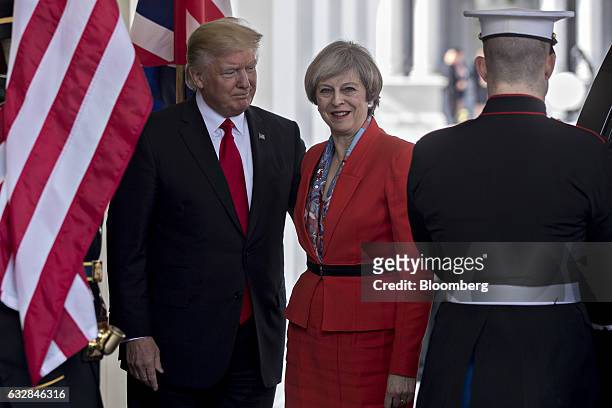 President Donald Trump, left, stands with Theresa May, U.K. Prime minister, while arriving to the West Wing of the White House in Washington, D.C.,...