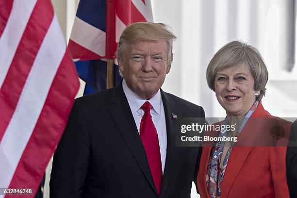 President Donald Trump, left, stands with Theresa May, U.K. Prime minister, while arriving to the West Wing of the White House in Washington, D.C.,...