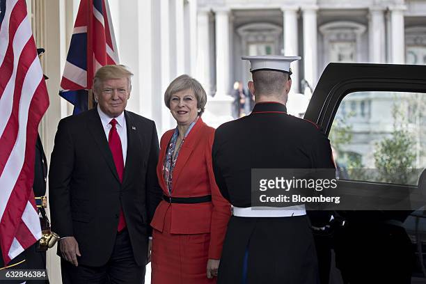 President Donald Trump, left, stands with Theresa May, U.K. Prime minister, while arriving to the West Wing of the White House in Washington, D.C.,...