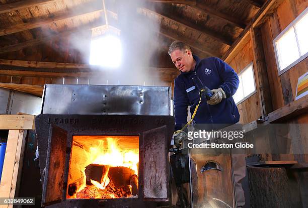 Mathew Noiseux uses a digital thermometer to check on the boiling maple water in the sugar shack where maple sugaring takes place at the Moose Hill...
