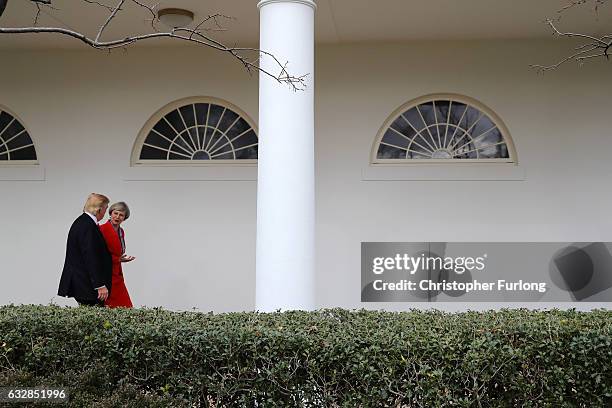 British Prime Minister Theresa May with U.S. President Donald Trump walk along The Colonnade at The White House on January 27, 2017 in Washington,...