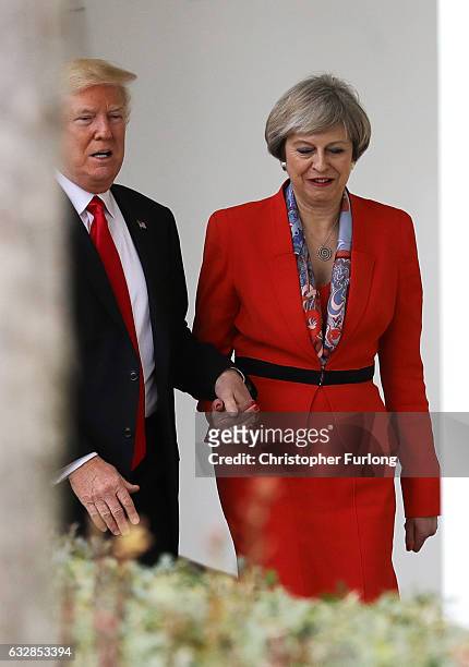 British Prime Minister Theresa May with U.S. President Donald Trump walk along The Colonnade at The White House on January 27, 2017 in Washington,...