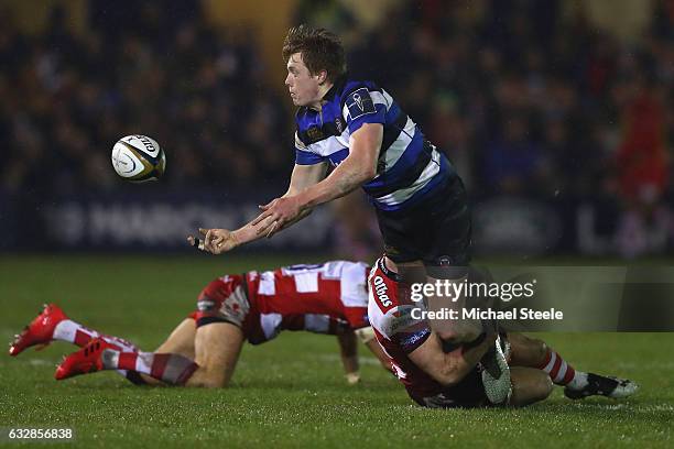 Harry Davies of Bath feeds a pass as he is tackled during the Anglo Welsh Cup match between Bath Rugby and Gloucester Rugby at the Recreation Ground...