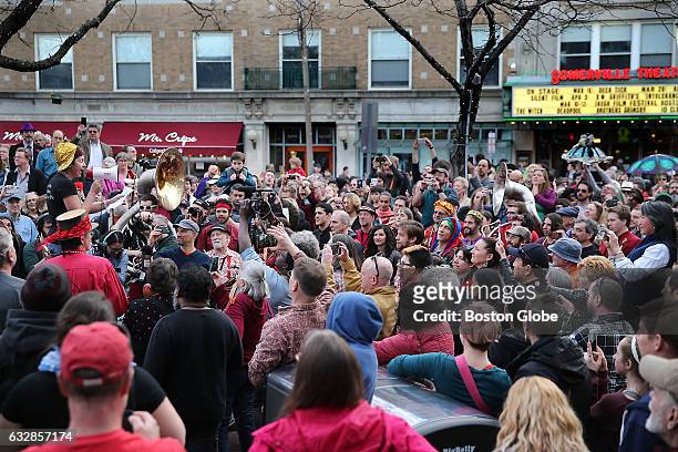 Johnny D's owner Carla DeLellis, standing with megaphone at left, thanks patrons and musicians following a brass band procession through Davis Square...