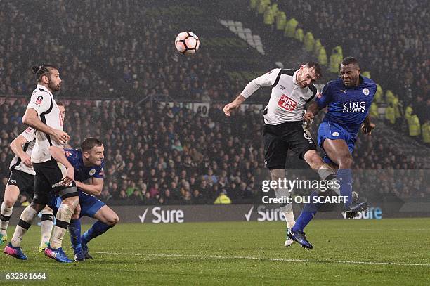 Leicester City's English-born Jamaican defender Wes Morgan heads the ball past Derby's English-born Irish defender Richard Keogh to score their...