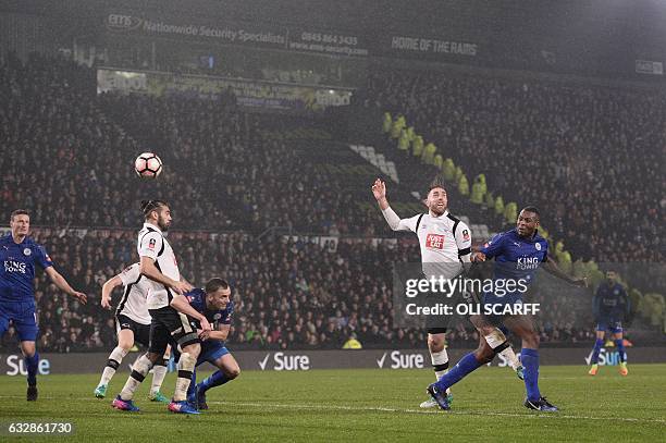 Leicester City's English-born Jamaican defender Wes Morgan heads the ball past Derby's English-born Irish defender Richard Keogh to score their...