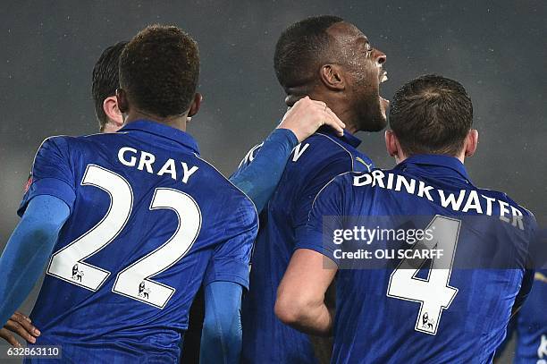 Leicester City's English-born Jamaican defender Wes Morgan celebrates with Leicester City's English midfielder Demarai Gray and Leicester City's...