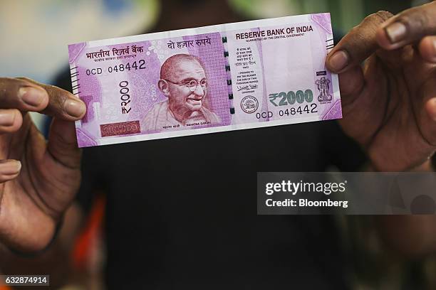 Man holds a two thousand Indian rupee banknote for a photograph in Mumbai, India, on Friday, Jan. 27, 2017. While economists urge more investment in...
