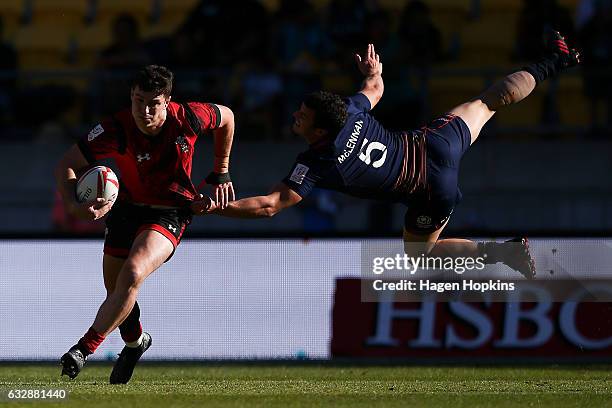 Owen Jenkins of Wales is tackled by Nick McLennan of Scotland in the pool match between Scotland and Russia during the 2017 Wellington Sevens at...