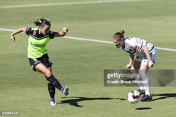 Canberra United's Hayley Russo passes passes around Annabel Martin of Melbourne Victory during the round 14 W-League match between Canberra United...