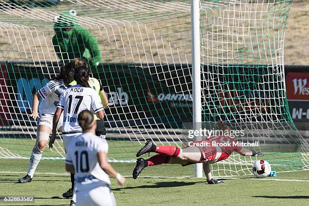 Melbourne Victory keeper Emily Kenshole fends away a ball as the 'United Frog' looks on in the background during the round 14 W-League match between...